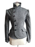 A gray textured wool-blend jacket with a high mock neck and dark buttons, displayed on a cream dress form mannequin.